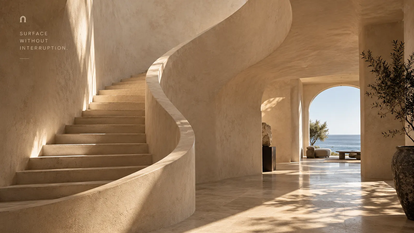 Limestone staircase curving through a coastal villa entry